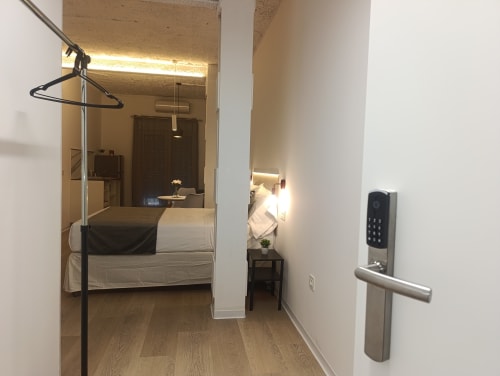 Entrada del apartamento El Rincón de Sevilla con cerradura digital, acceso al dormitorio con mobiliario moderno