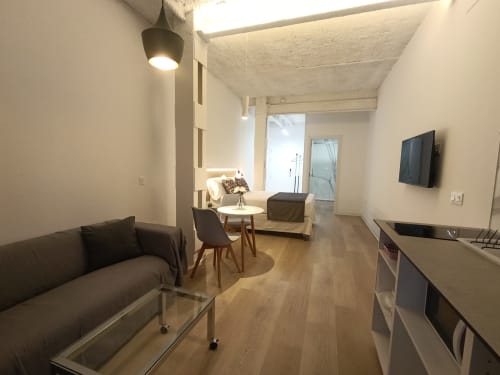 Moderno salón de apartamento en El Rincón de Sevilla con sofá, TV, cocina americana y mobiliario contemporáneo en Sevilla