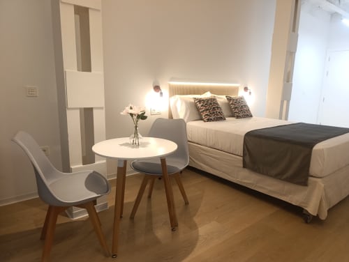 Dormitorio moderno en apartamento El Rincón de Sevilla con cama, zona de descanso y pisos de madera