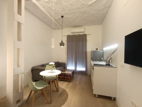 Moderno apartamento estudio en Sevilla con zona de comedor, sofá, TV y cocina americana