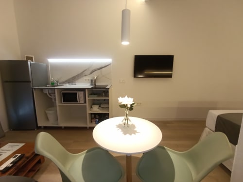 Moderno estudio en Sevilla con mesa de comedor redonda, cocina y cómoda sala de estar