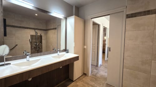 Modernes Badezimmer in den Villas Lantana in Lecci mit Doppelwaschbecken, großem Spiegel und begehbarer Dusche