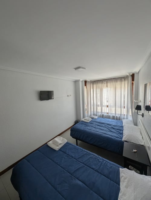 Habitación triple con dos camas individuales en Alojamiento La Ballena de Santoña, baño compartido y vistas al mar
