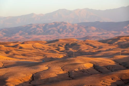 Golden desert landscape with rolling sand dunes and mountains, Marrakech, Morocco at sunset