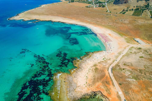 Spiaggia turchese di San Vito Lo Capo con costa rocciosa e pianure costiere, vicino al B&B Le Biciclette.