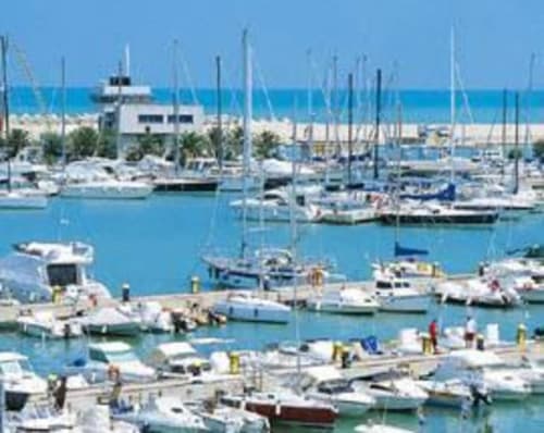 Pescara marina with moored sailboats and yachts under blue sky, Italian coastal harbor view