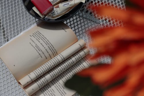 Open book with white highlighters and red accessories on mesh table at Pescara INN Beach House apartment