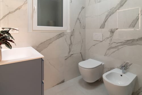 Modern bathroom at Pescara INN Beach House with marble-effect tiles, wall-mounted toilet, bidet, and floating vanity
