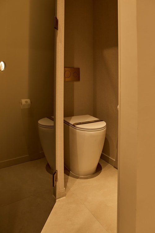 Modern bathroom in Arrels Mercat apartment, Valencia, with contemporary white toilet and warm-toned walls