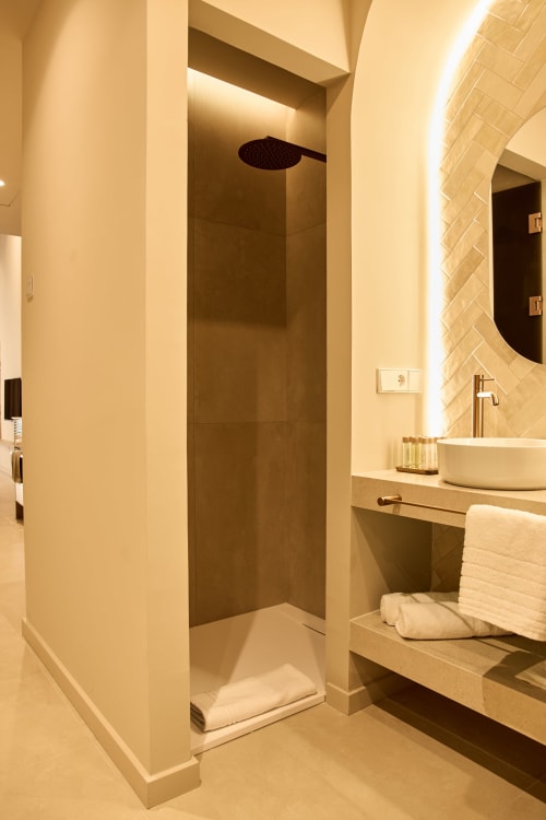 Modern bathroom shower with rainfall showerhead at Arrels Mercat apartments in Valencia, Spain