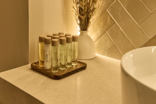 Luxury bathroom amenities on wooden tray at Arrels Mercat apartment in Valencia, Spain