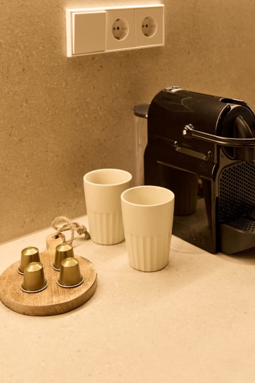 Coffee station in Arrels Mercat apartment with espresso machine, cups, and capsule holder in Valencia