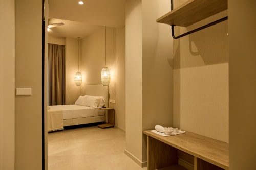 Modern apartment bedroom and walk-in closet at Arrels Mercat hotel in Valencia with pendant lighting and wooden shelving