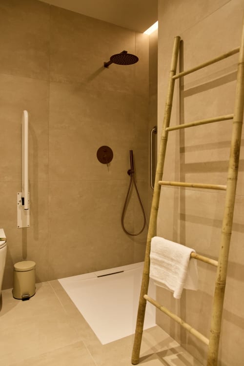 Modern bathroom with walk-in shower, bamboo towel ladder, and heated fixtures at Arrels Mercat apartment in Valencia