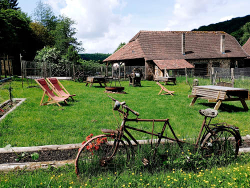 Jardin de la maison d'hôtes Paulusmühle à Soucht avec vélos, places assises et grange rustique en arrière-plan