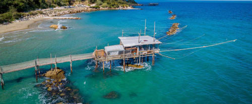 Wooden pier structure with white canopy in turquoise Adriatic waters near Pescara, Italy beach resort