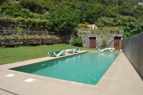 Piscina turquesa com espreguiçadeiras em A Casa Estrelícia-Dourada Garcês em São Vicente, Portugal