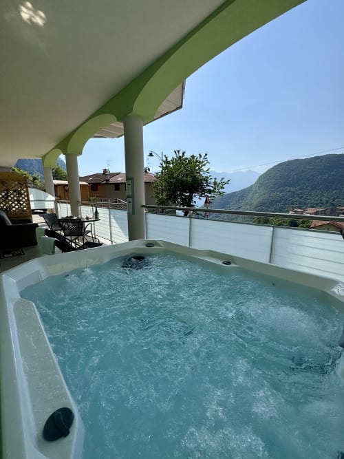 Vasca idromassaggio sulla terrazza della villa con vista sulle montagne a Ranzo, Italia presso Alloggi Zoe