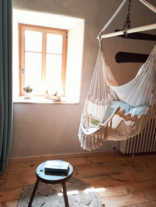 Hamac douillet dans la chambre ensoleillée du gîte Paulusmühle à Soucht, France, avec fenêtre en bois et décor rustique