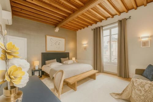Chambre lumineuse de la suite Gabriel 2 pièces au Maunoury Citybreak Chartres avec plafond à poutres, lit queen-size et jardin