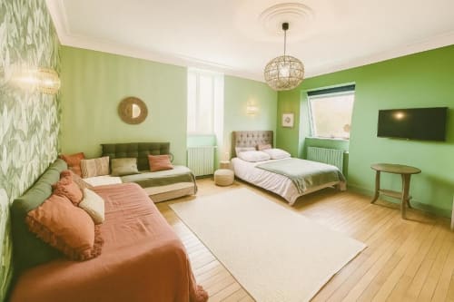 Suite Gabriel 2 chambres à Maunoury Citybreak à Chartres avec murs verts, canapé, lit, parquets et vue jardin