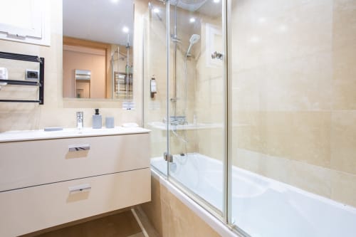Baño moderno con tocador, espejo y ducha de cristal en el apartamento Haus Holiday Homes de San Pedro del Pinatar