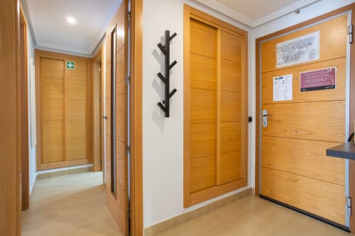 Pasillo moderno con puertas de madera y perchero negro en Haus Holiday Homes, San Pedro del Pinatar