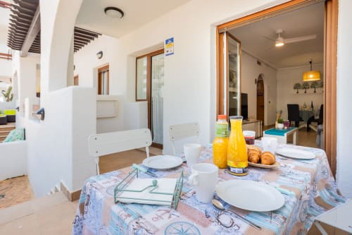 Luminoso comedor en apartamento de San Pedro del Pinatar con mesa preparada, acceso a cocina y mobiliario moderno