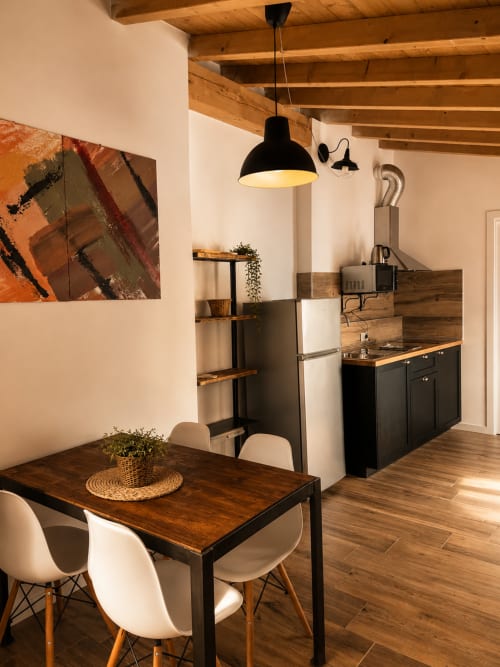 Modernes Loft in Bergamo mit Essbereich, schwarzer Pendelleuchte, Holzbalken und zeitgenössischer Kitchenette