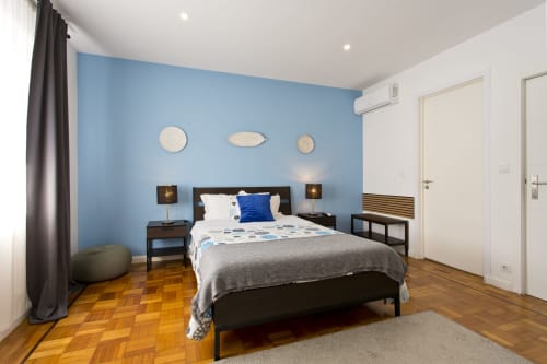 Modern family bedroom at 100 Contos B&B Porto with blue accent wall, black bed, wooden floors, and city view amenities