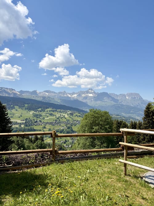 Clôture en bois surplombant la vallée alpine verdoyante et les montagnes à La Ferme 1828 B&B, Demi-Quartier