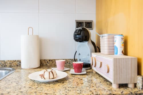 Encimera de la cocina en apartamento Haus Holiday Homes con cafetera, toallas de papel y artículos para desayuno en mesón de granito