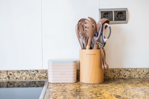 Encimera de cocina con soporte de utensilios de madera, salero y tijeras en el apartamento Haus Holiday Homes en San Pedro del