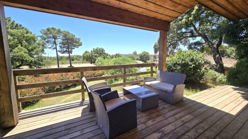 Covered terrace at Villas Lantana with rattan seating, wooden deck, and views of Lecci countryside in Corsica