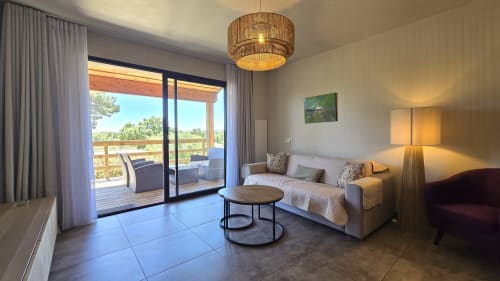 Bright villa bedroom in Lecci with terrace, sofa bed, modern lighting, and scenic views at Villas Lantana