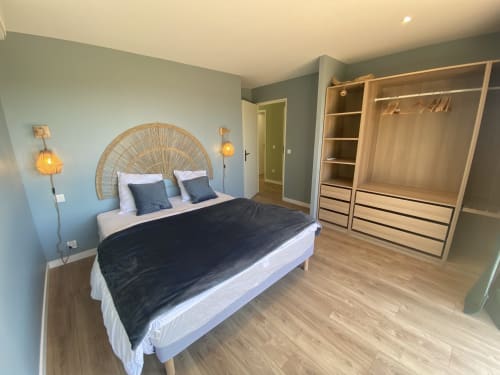 Chambre moderne de la villa CASA DI SADREA à Lecci avec tête de lit en rotin, literie noire, armoire en bois et décor contemporain