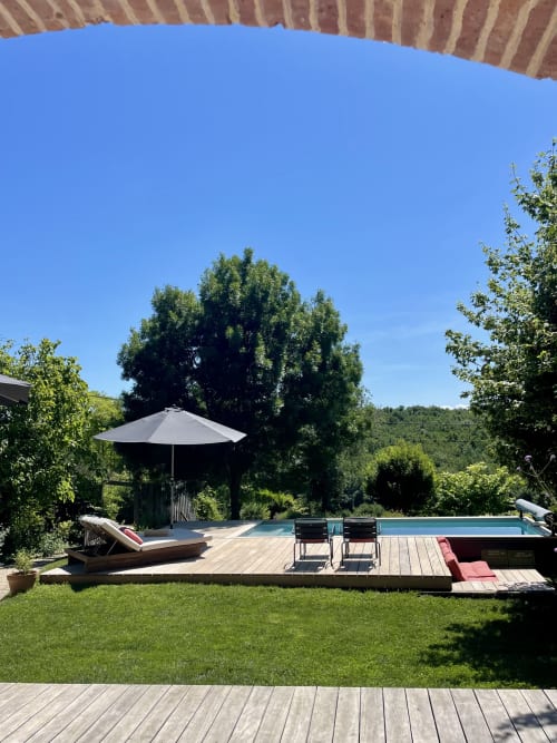 Maison Monsieur Léger, location de vacances à Montaut avec terrasse au bord de la piscine, chaises longues, parasol et jardins verdoyants