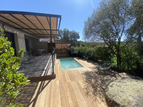Piscine turquoise avec terrasse en bois, pergola et jardin luxuriant de la villa Casa di Sadrea à Lecci