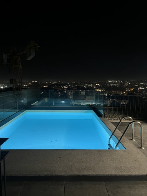 Piscina iluminada na cobertura da Timeless Vacations Douro Tower, Arcozelo, com luzes noturnas da cidade