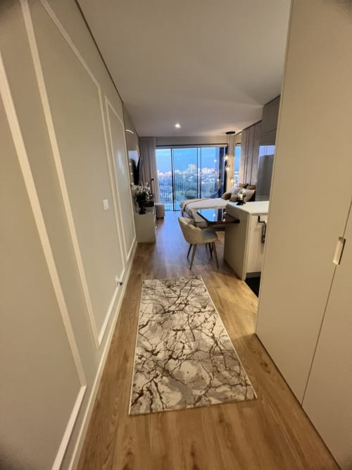 Corredor moderno com piso de madeira, tapete decorativo e vistas panorâmicas do rio Douro na Timeless Vacations