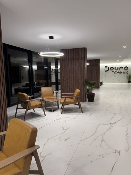 Saguão moderno da Torre Douro em Timeless Vacations Arcozelo com cadeiras bege, piso em mármore e iluminação contemporânea