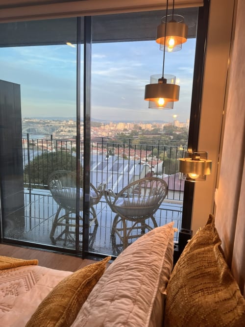 Estúdio da Torre Douro na Timeless Vacations com vista para o rio, luminárias pendentes e cadeiras de vime na varanda com vista para Arcozelo