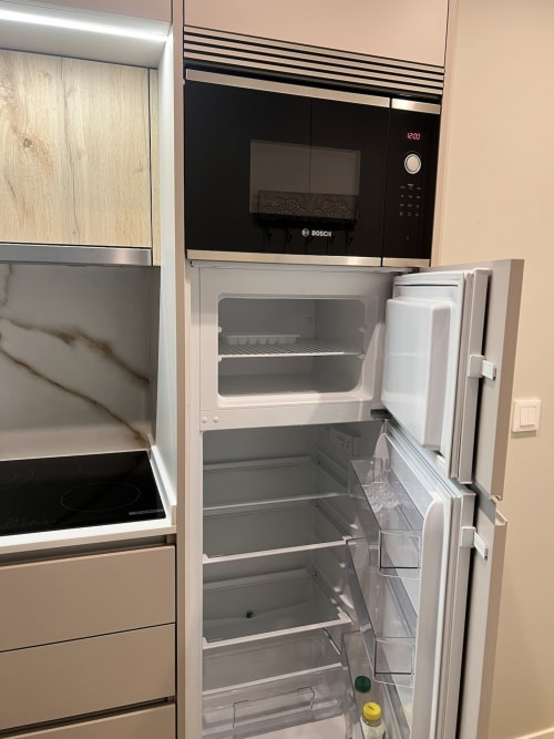 Cozinha moderna do estúdio Timeless Vacations em Arcozelo com geladeira aberta e micro-ondas Bosch acima