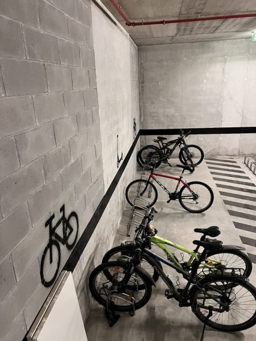 Sala segura de armazenamento de bicicletas na Timeless Vacations Arcozelo com várias bicicletas estacionadas em piso listrado