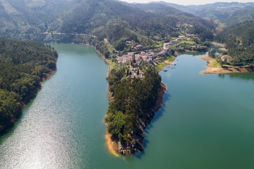 Vista aérea da Quinta da Mata de Baixo aninhada em península entre lagos turquesas em Cagida, Portugal cercada por