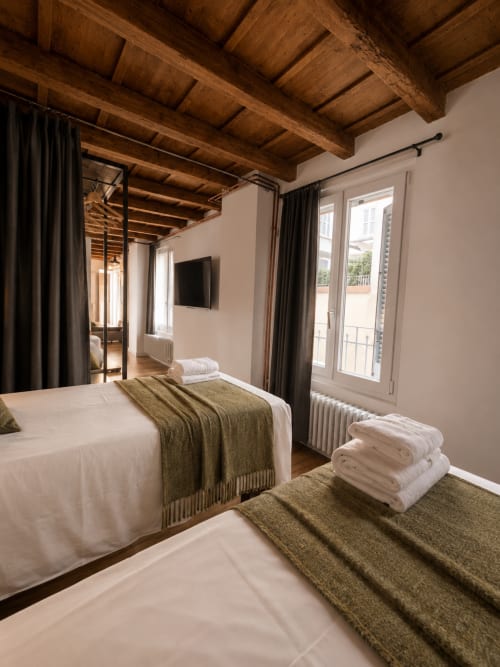 Modernes Loft-Schlafzimmer in Borgovivobg Bergamo mit Holzbalken, Doppelbetten, TV und Balkonzugang