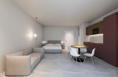 Junior Suite moderna presso Holiday Suites con letto, zona living, tavolo da pranzo e angolo cottura in tonalità neutre