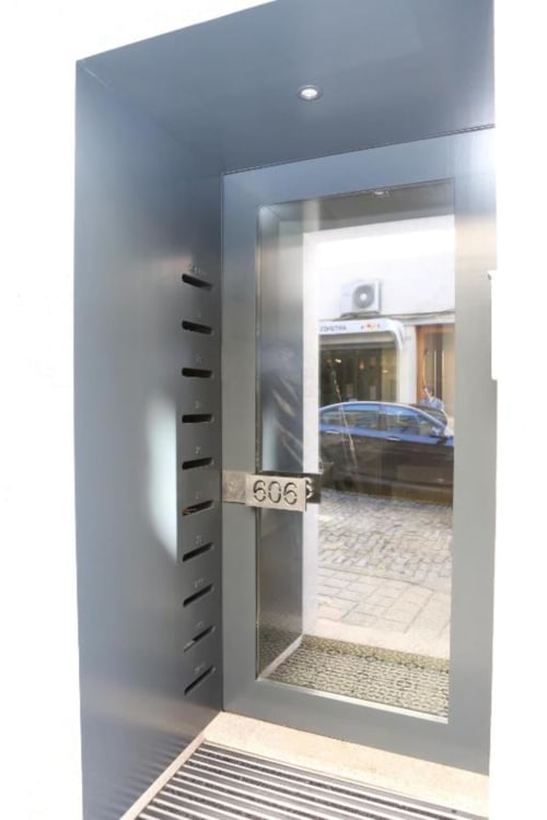 Entrada moderna do apartamento Timeless Vacations Porto com porta numerada 606, fachada de vidro e design contemporâneo