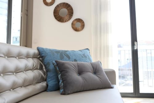 Sala de estar moderna em apartamento no Porto com sofá bege, almofadas com padrão azul, espelhos decorativos e varanda com vista para a cidade