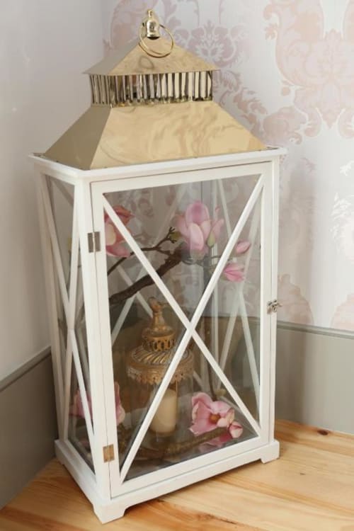 Lanterna branca decorativa com flores rosa e detalhes dourados em apartamento no Porto